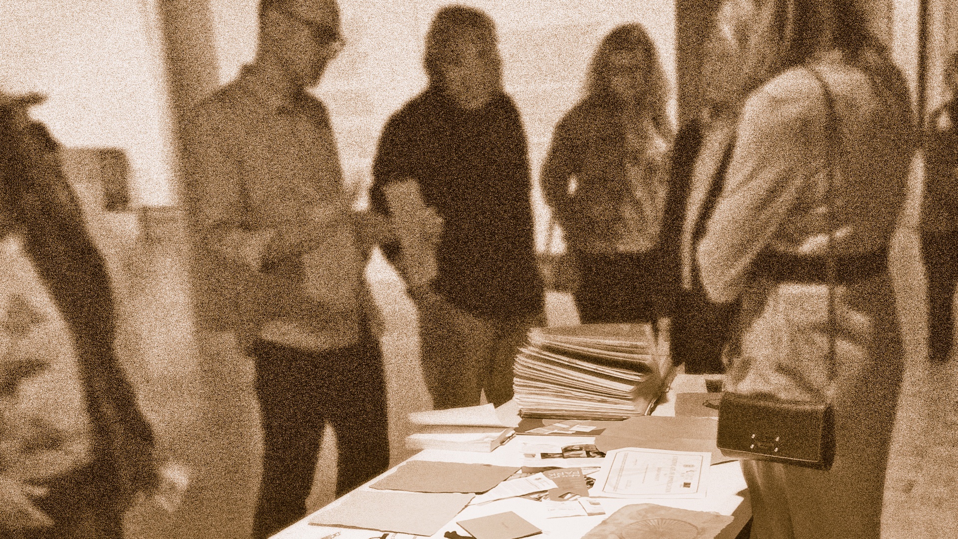 People gathered around a table looking at unframed fine art prints.